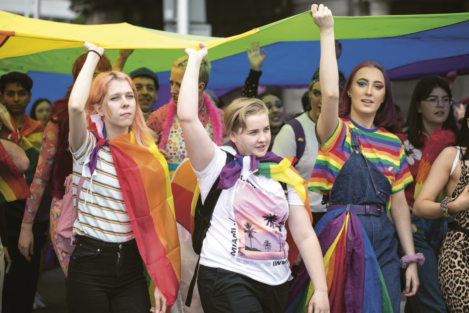 LGBTQIA+ people carry a rainbow flag